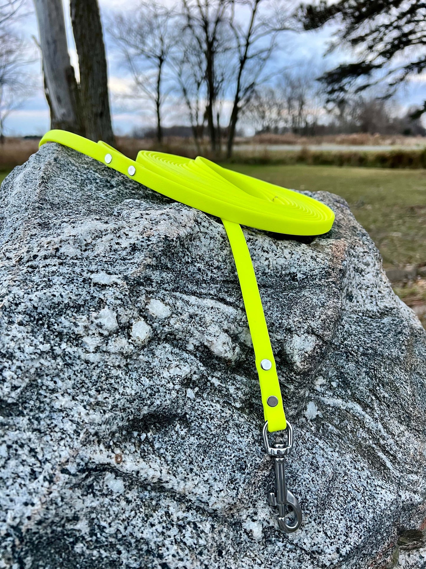 A durable neon yellow biothane dog long lead with contrasting nickel plated hardware, designed for strength and style, ideal for everyday use and outdoor adventures. Great for training recall and the beginning steps of off leash dog training.
